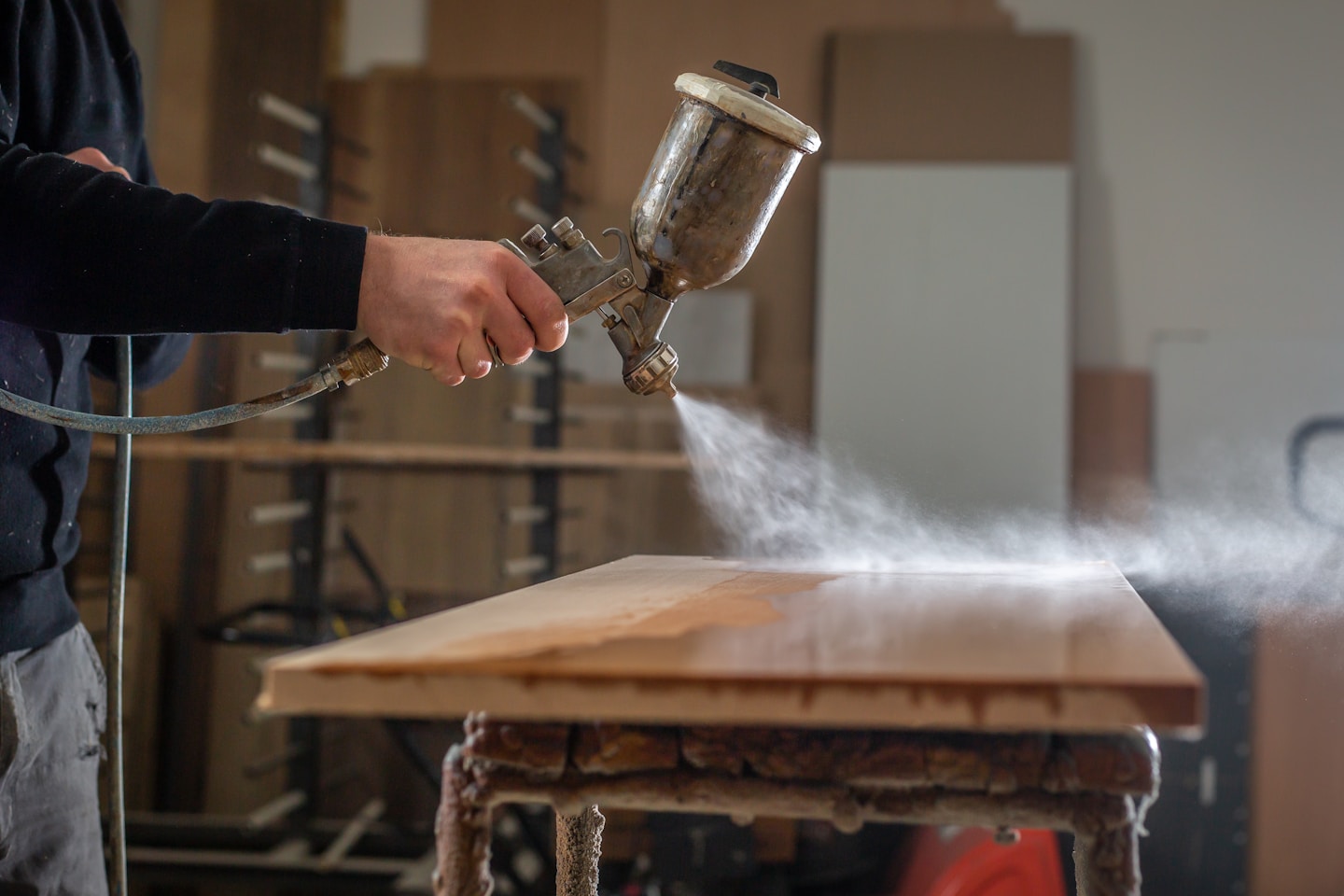 Staining wood with white spray gun,  application of flame retardant ensuring fire protection, airless spraying device, industrial concept